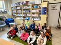 dzieci siedzą na dywanie w czytelni