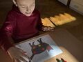 chłopiec układa pompony na kropkach umieszczonych na sylwecie kota