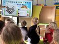 dzieci kodują sylwetę kota na ekranie multimedialnym