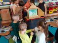 Dzieci bawią się pacynkami w drewnianym teatrzyku