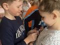 wręczanie podarunku przez chłopców dziewczynkom