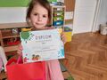 dziewczynka trzyma dyplom za zajęcie II miejsca w konkursie FOOD