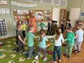 dzieci tańczą z nauczycielką przebraną za wiosnę