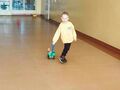 dziecko ciągnie wózek zabawkowy z misiem