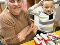 babcia z wnuszkiem przy stoliku w sali przedszkolnej