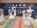 dziewczynki ubrane na biało tańczą z gwiazdami nad głową