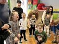sala przedszkola dzieci z babciami i dziadkami tańczą w sali