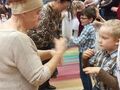 sala przedszkolna na przeciw siebie stoją babcie i wnuczęta
