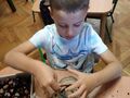 Chłopiec wkłada patyk do słoika