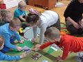 Dzieci siedzą na dywanie i dopasowują nazwy ptaków do ich zdjęćjpg
