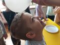 Chłopiec sprawdza balonem czy elektryzują się jego włosy