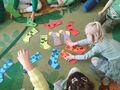 dzieci na dywanie dobierają w pary papierowe skarpetki