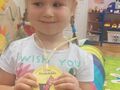 Dziewczynka pokazuje medal Przedszkolaka