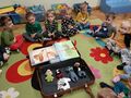 Dzieci siedzą w kręgu, na środku walizka z książkami i pacynkami