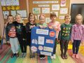 Grupa dzieci trzyma plakat informacyjny zachęcający do rzucenia palenia