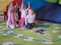dzieci pod kolorową chustą