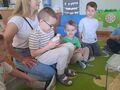 chłopiec na kolanach mamy pokazuje i opowiada o kurczakach