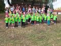 Dzieci w sportowych strojach stoją z flagami Polski