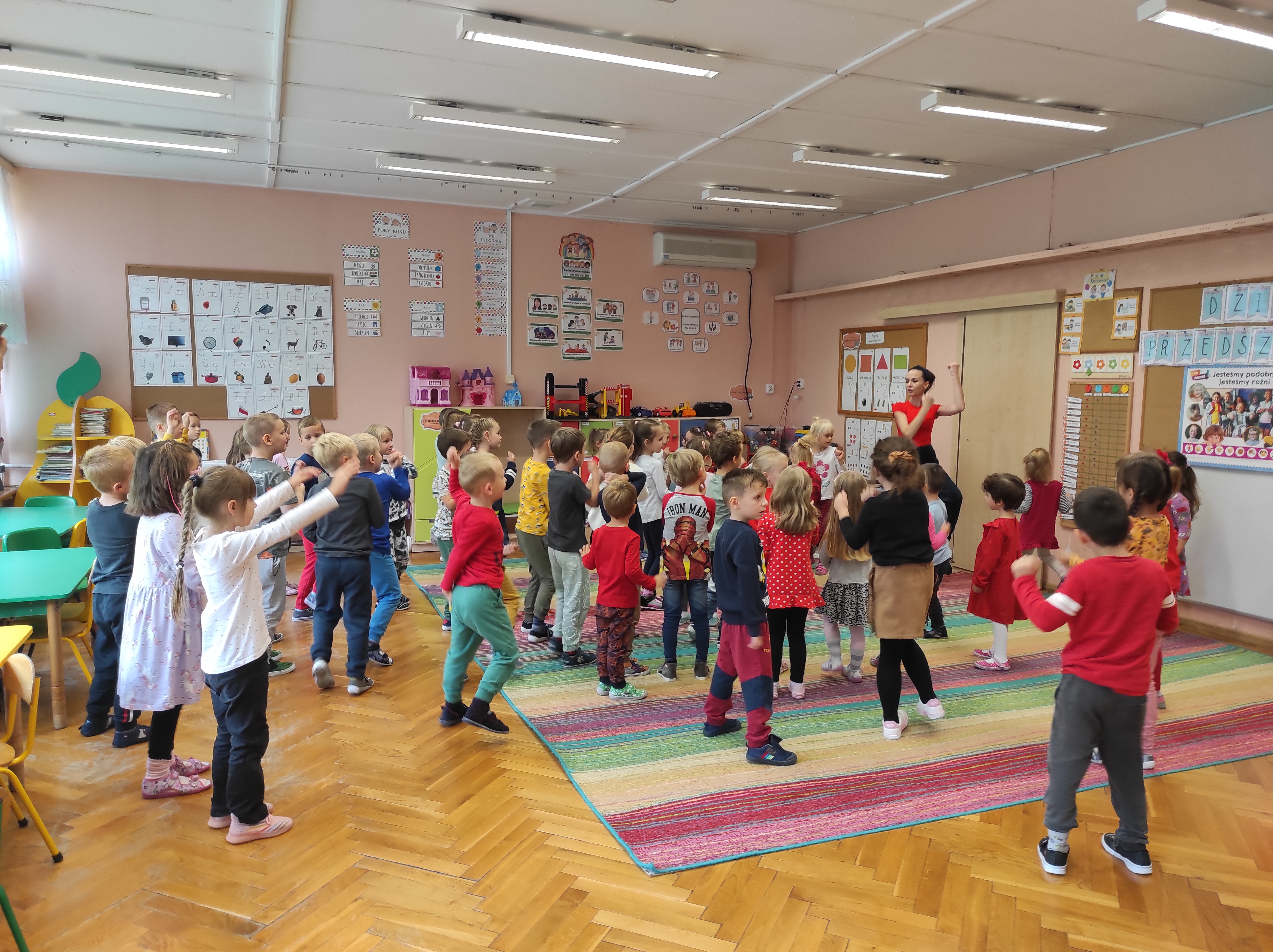 Grupa dzieci tańczy pod instruktażem nauczycielki