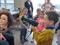 Chłopiec w salonie fryzjerskim suszy włosy suszarką.