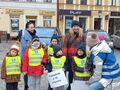 Przedszkolaki wraz z nauczycielkami stoją na placu. Trzymają napis Przedszkole Nr 10 w Koninie