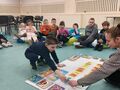 chłopiec układa na macie napis biblioteka