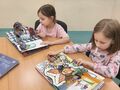 dziewczynki oglądające książki z przestrzennymi ilustracjami