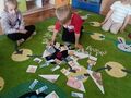 sala przedszkolna dziecko układa na dywanie puzzle przedstawiające różne rodzaje pieczywa