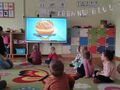 dzieci oglądają prezentację o pączkach na ekranie multimedialnym