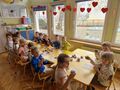 dzieci przy stolikach sala przedszkolna jedzą babeczki