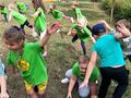 Dzieci w zielonych koszulkach ćwiczą na świeżym powietrzu