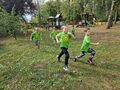 Dzieci w zielonych koszulkach biegną