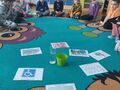 sala przedszkolna dzieci siedzą na dywanie i oglądają plansze