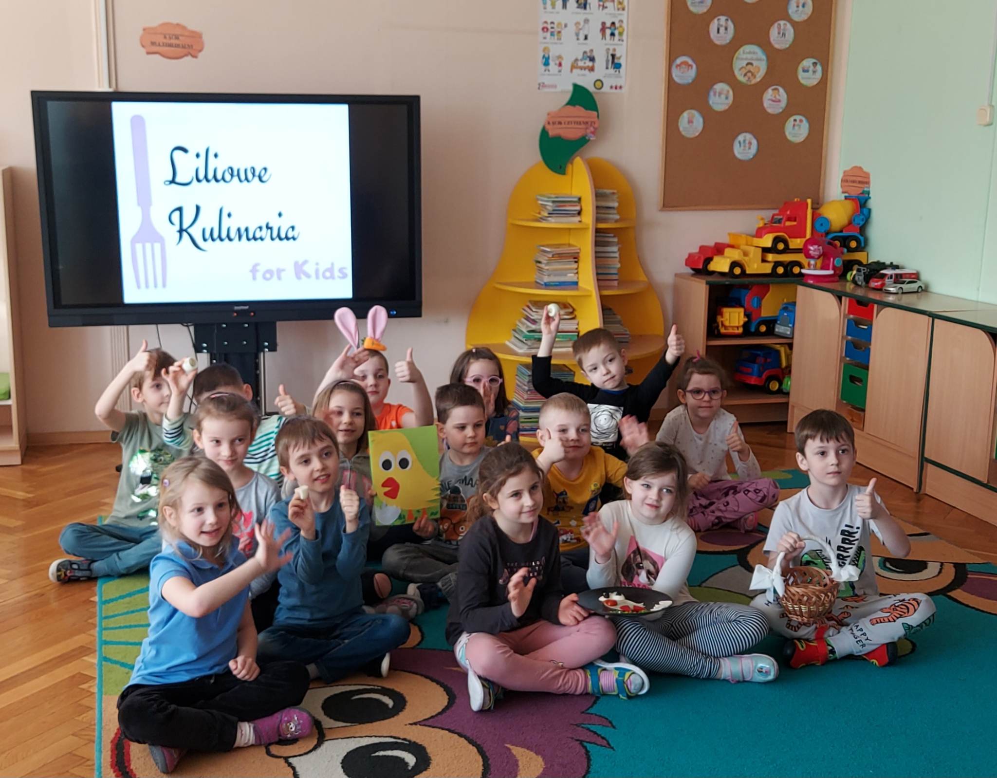 dzieci siedzą na dywanie z koszykami świątecznym 