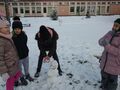 Czwórka dzieci lepi bałwana