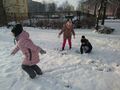 Trójka dzieci bawi sie w śniegu